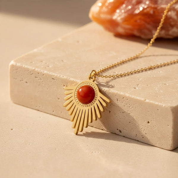 Pendentif cornaline orangée sur soleil doré à longs rayons, collier pierre rouge