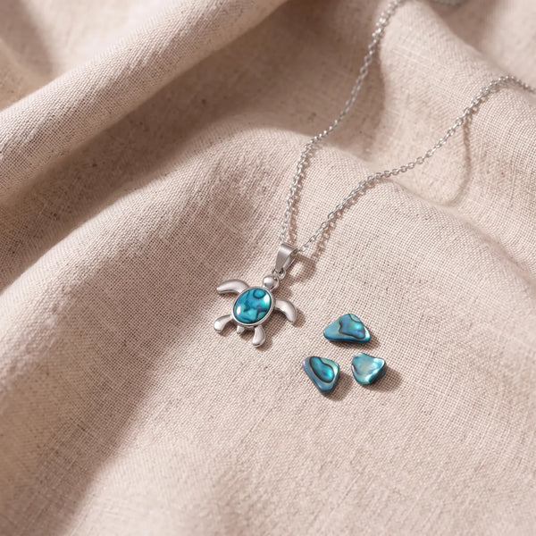 Pendentif tortue en nacre d'ormeau bleue sur un lin naturel avec des éclats de nacre