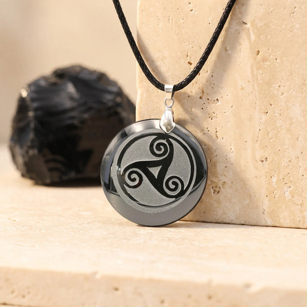 Pendentif triskel celtique gravé sur un disque d'obsidienne noire