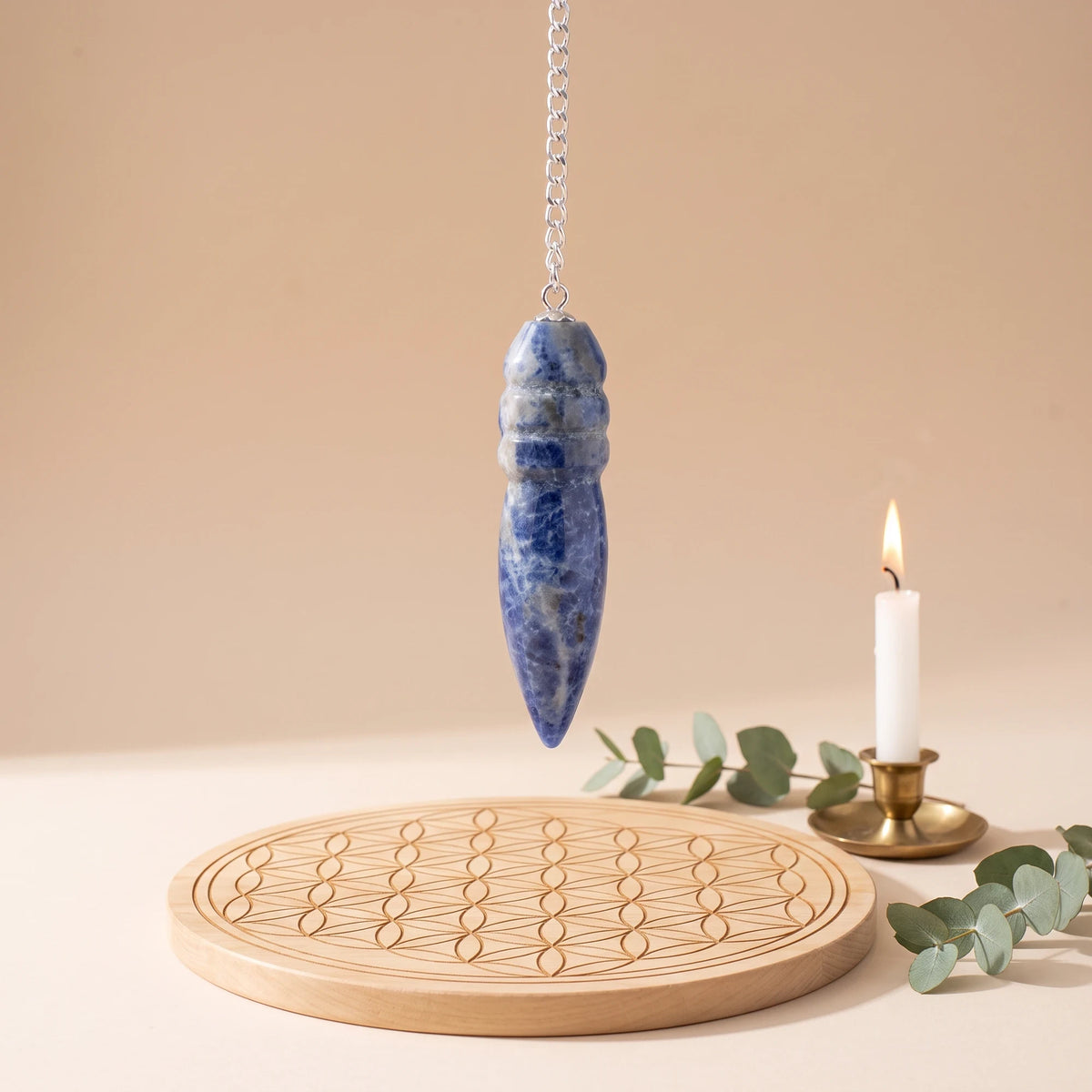 Pendule bleu égyptien en sodalite pour la radiesthésie sur planche Fleur de Vie