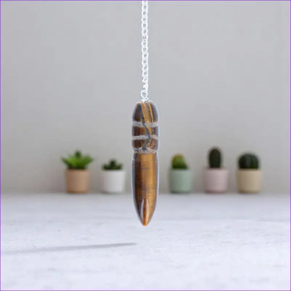 Gros plan sur la forme précise du Pendule Égyptien (Oeil de Tigre) en pierre naturelle