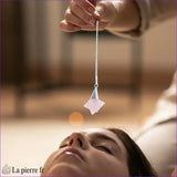 Pendule Merkaba (Quartz Rose) forme étoile géométrique tenu délicatement - La Pierre Fr