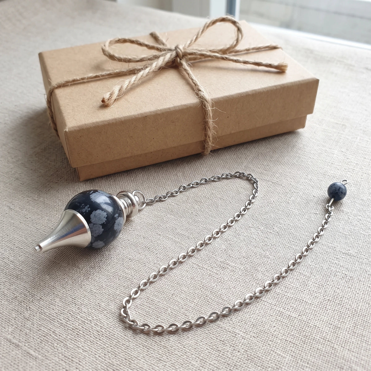 Pendule en obsidienne neige, idée cadeau présentée avec sa boîte