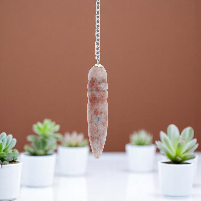 Pendule de vitalité Égyptien (Pierre de Soleil) avec chaîne argentée sur fond lumineux