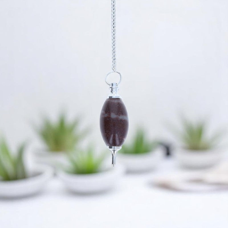 Pendule divinatoire (Shiva Lingam) forme ovoïde avec chaîne argentée sur fond texturé