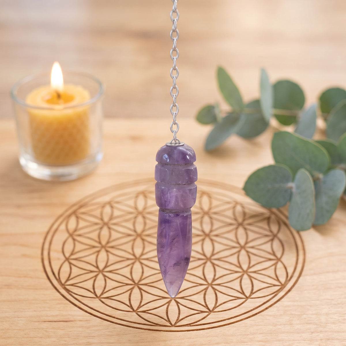 Pendule violet égyptien en améthyste pour la radiesthésie sur planche Fleur de Vie