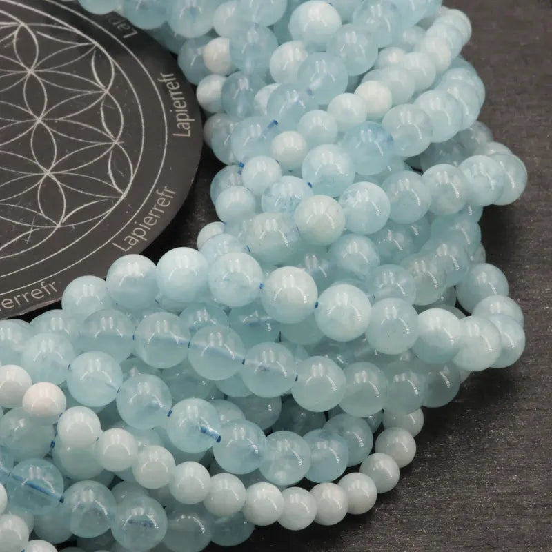 Gros plan sur des perles d'Aigue Marine, pierre naturelle douce pour bracelet et collier de lithothérapie