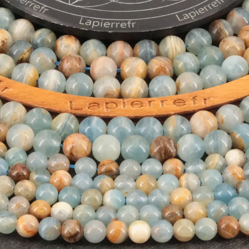 Gros plan sur Perles Calcite Bleue (Qualité AA+) montrant la couleur bleu clair et la qualité AA+.