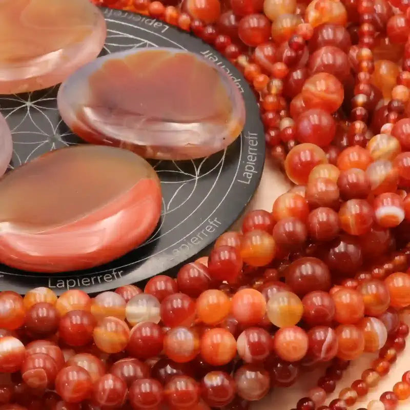 Gros plan sur des perles d'Agate Rouge, pierre naturelle pour bracelet et collier de lithothérapie