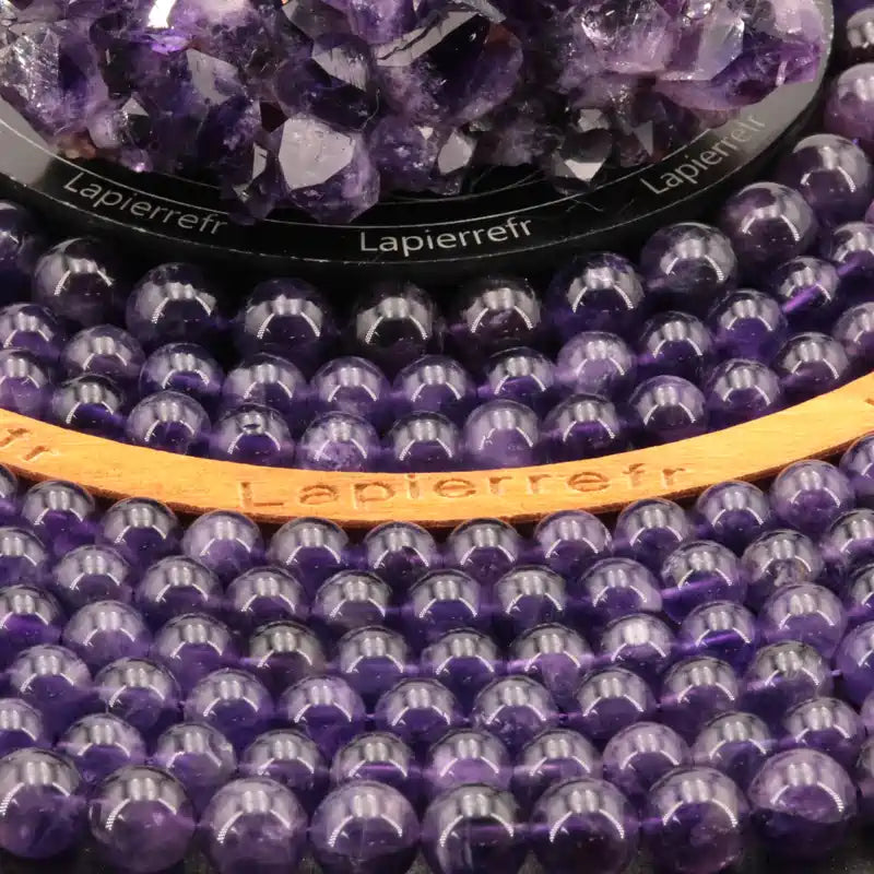 Gros plan sur Perles Améthyste (Qualité AA+) montrant la couleur violet profond et la qualité AA+