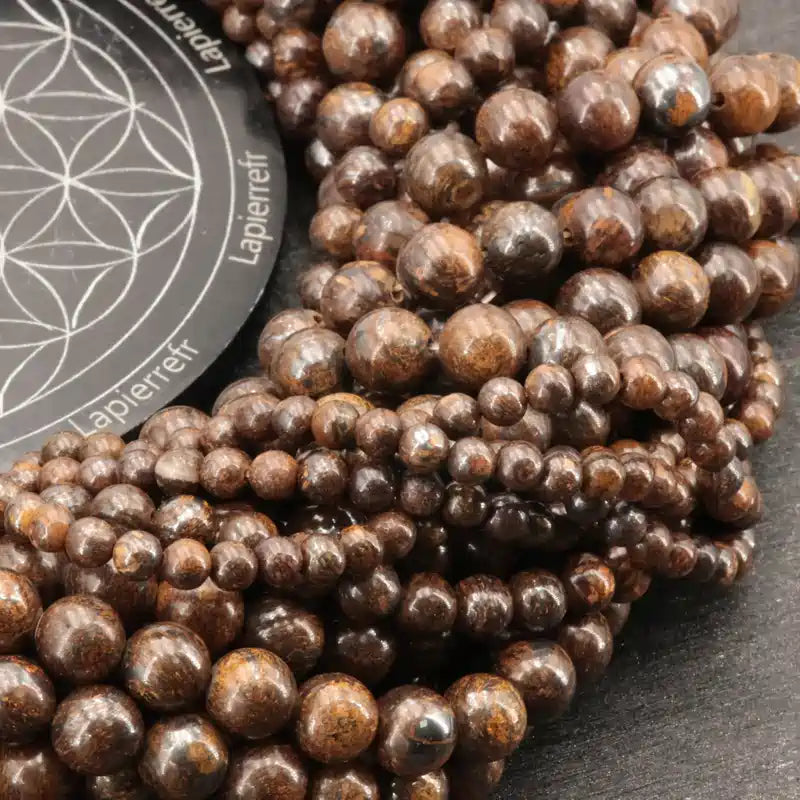 Gros plan sur des perles de Bronzite aux reflets bronze, pierre naturelle pour bracelet et lithothérapie
