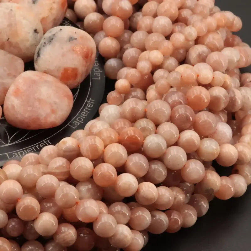 Gros plan sur des perles de Pierre de Soleil aux reflets dorés, pierre naturelle pour bracelet et collier
