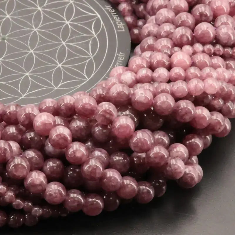 Gros plan sur des perles de Lépidolite violette, pierre naturelle lilas pour bracelet et collier de lithothérapie