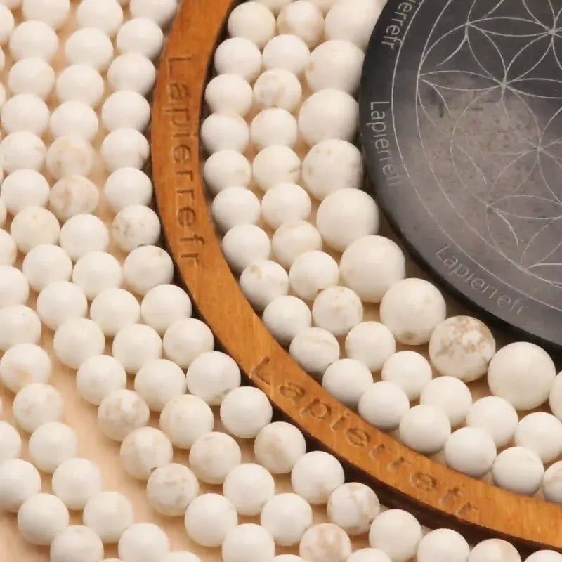 Gros plan sur des perles de Magnésite blanche, pierre naturelle apaisante pour bracelet et collier