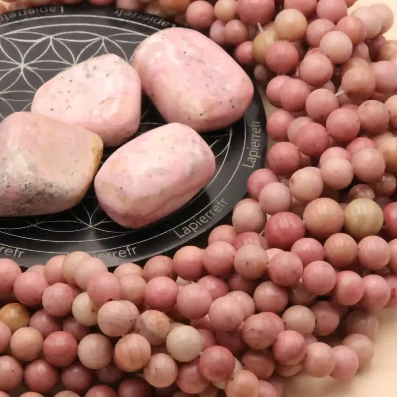 Gros plan sur des perles de Rhodonite rose, pierre naturelle douce pour bracelet et collier