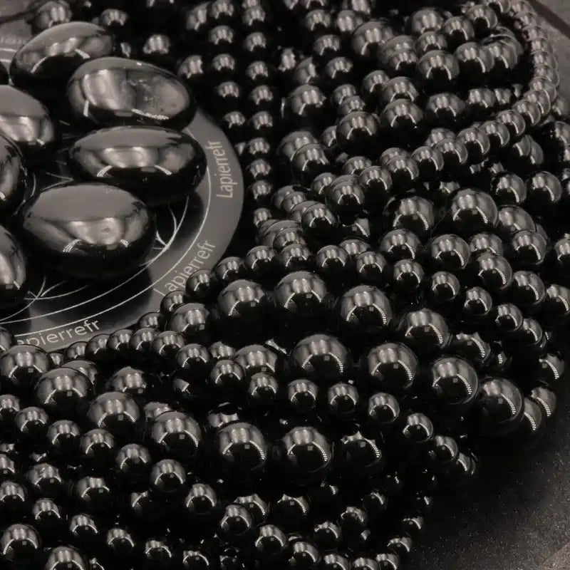 Gros plan sur des perles de Tourmaline noire, pierre naturelle d'ancrage pour bracelet et collier