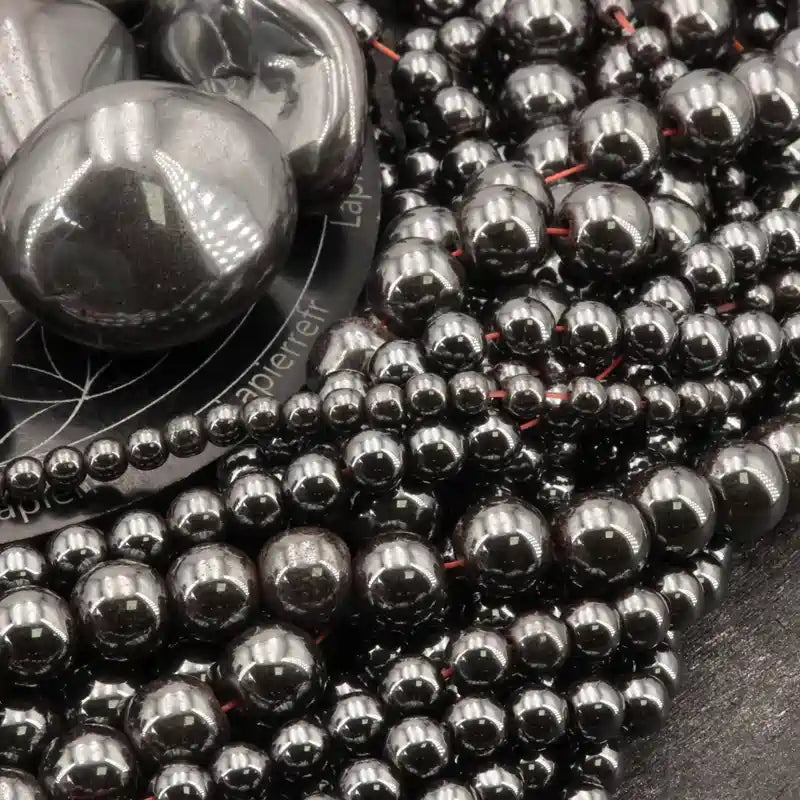 Gros plan sur des perles d'Hématite brillante, pierre naturelle pour bracelet et collier de lithothérapie