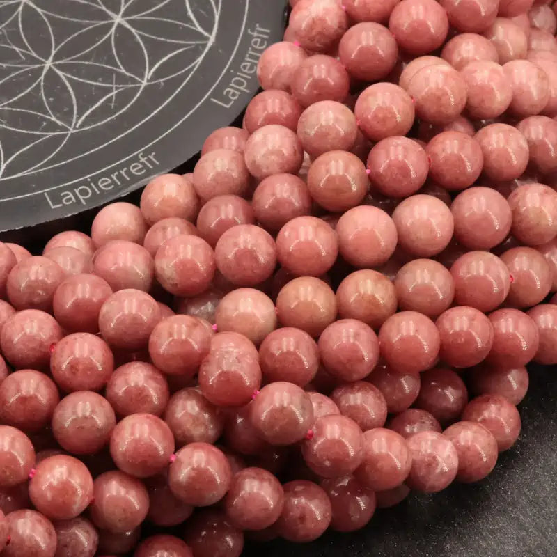Gros plan sur Perles Thulite (Qualité AA+) montrant la couleur rose et les inclusions blanches caractéristiques.
