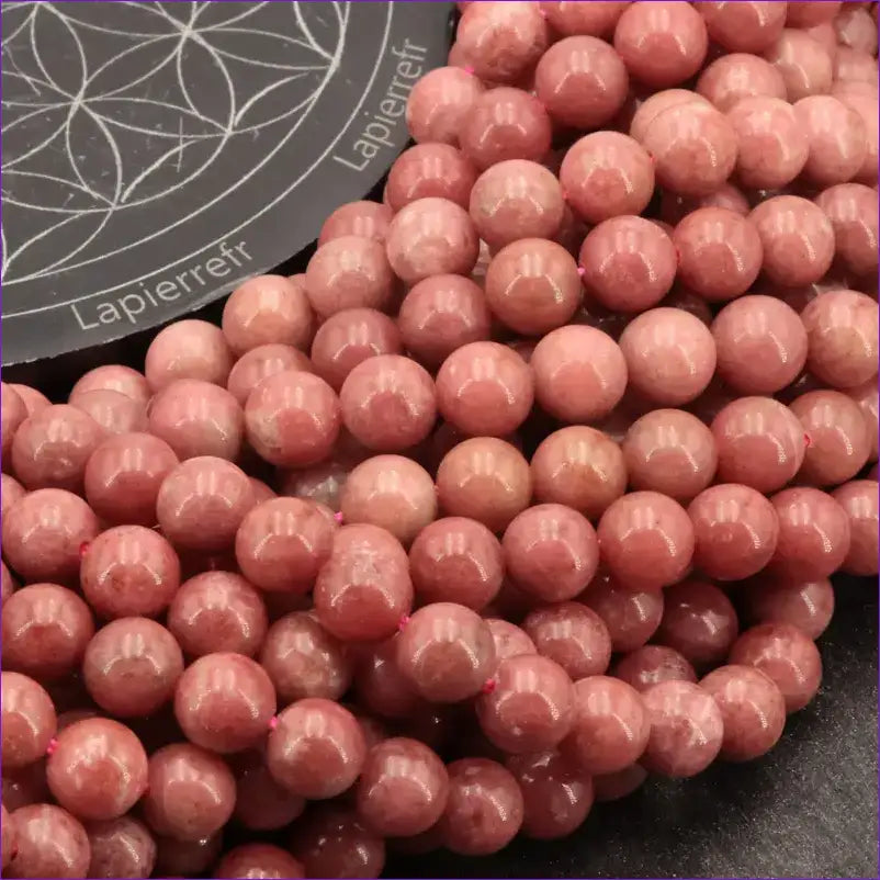 Gros plan sur Perles Thulite (Qualité AA+) montrant la couleur rose et les inclusions blanches caractéristiques.