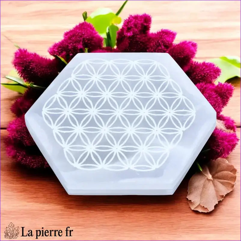 Plaque de rechargement hexagonale en sélénite naturelle avec Fleur de Vie. Purifiez et rechargez vos pierres avec une géométrie sacrée puissante.