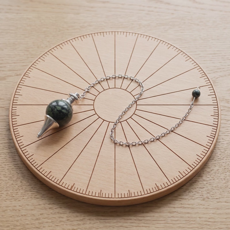 Pendule séphoroton en jaspe kambaba sur une planche de radiesthésie