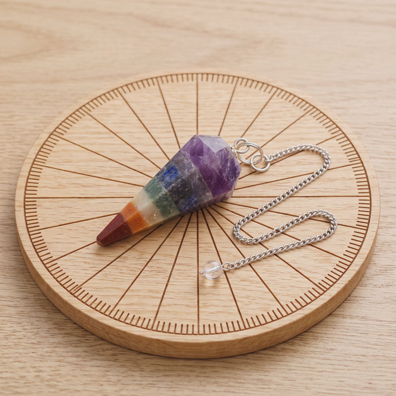 Pendule chakra facetté sur une planche de radiesthésie