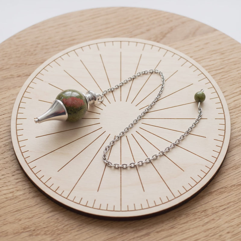 Pendule séphoroton en unakite sur une planche de radiesthésie