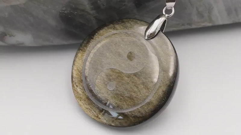 Vidéo du pendentif yin yang en obsidienne dorée et de ses reflets