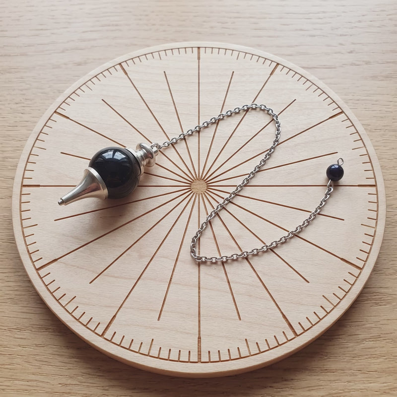 Pendule séphoroton en tourmaline noire sur une planche de radiesthésie