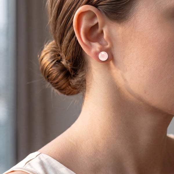 Puce d'oreille boule de quartz rose pâle portée par une femme, tout en douceur