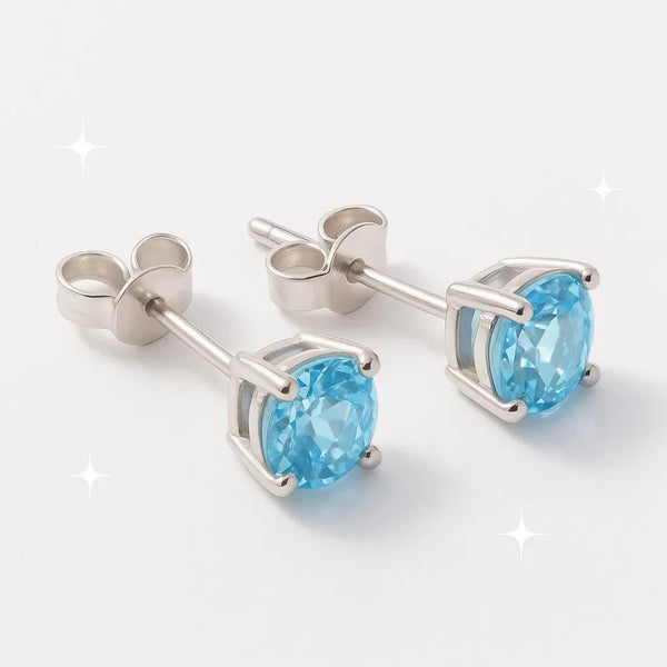 Boucles d'oreilles Asterion en topaze bleue et argent 925 rhodié, présentées sur un support