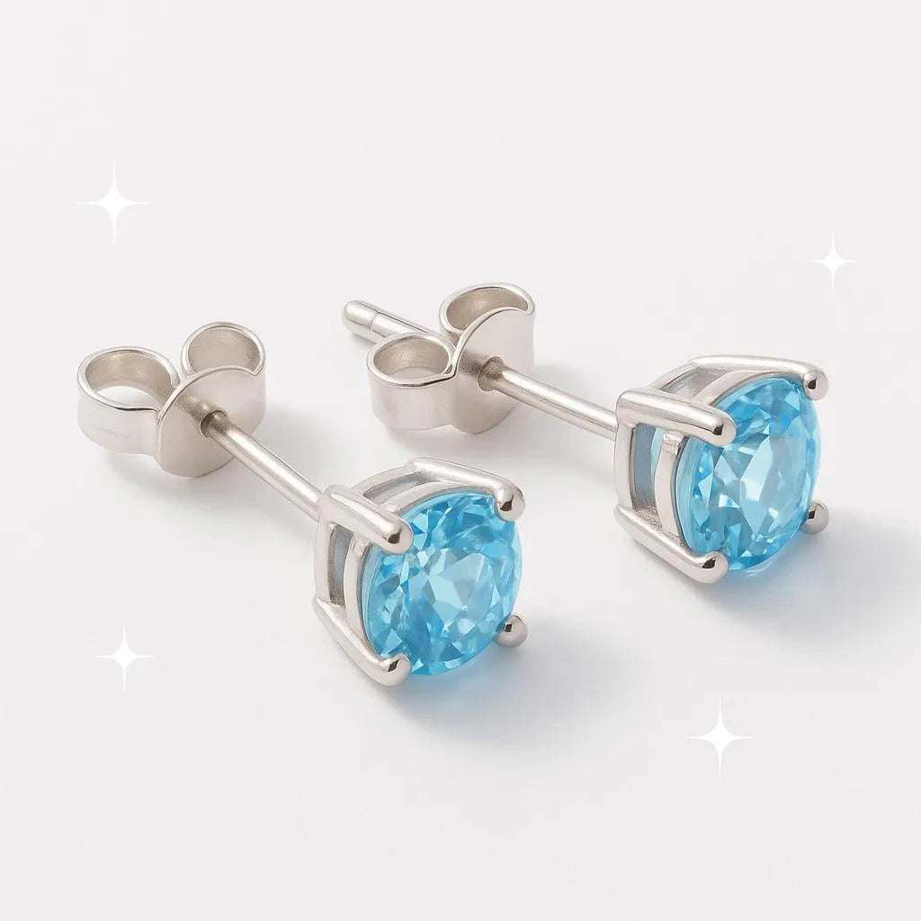 Boucles d'oreilles Asterion en topaze bleue et argent 925 rhodié, présentées sur un support