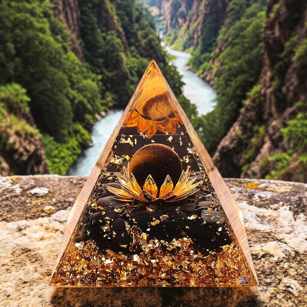 Détail de l'œil de tigre et de l'obsidienne noire naturels avec motif lotus dans la pyramide orgonite 60mm