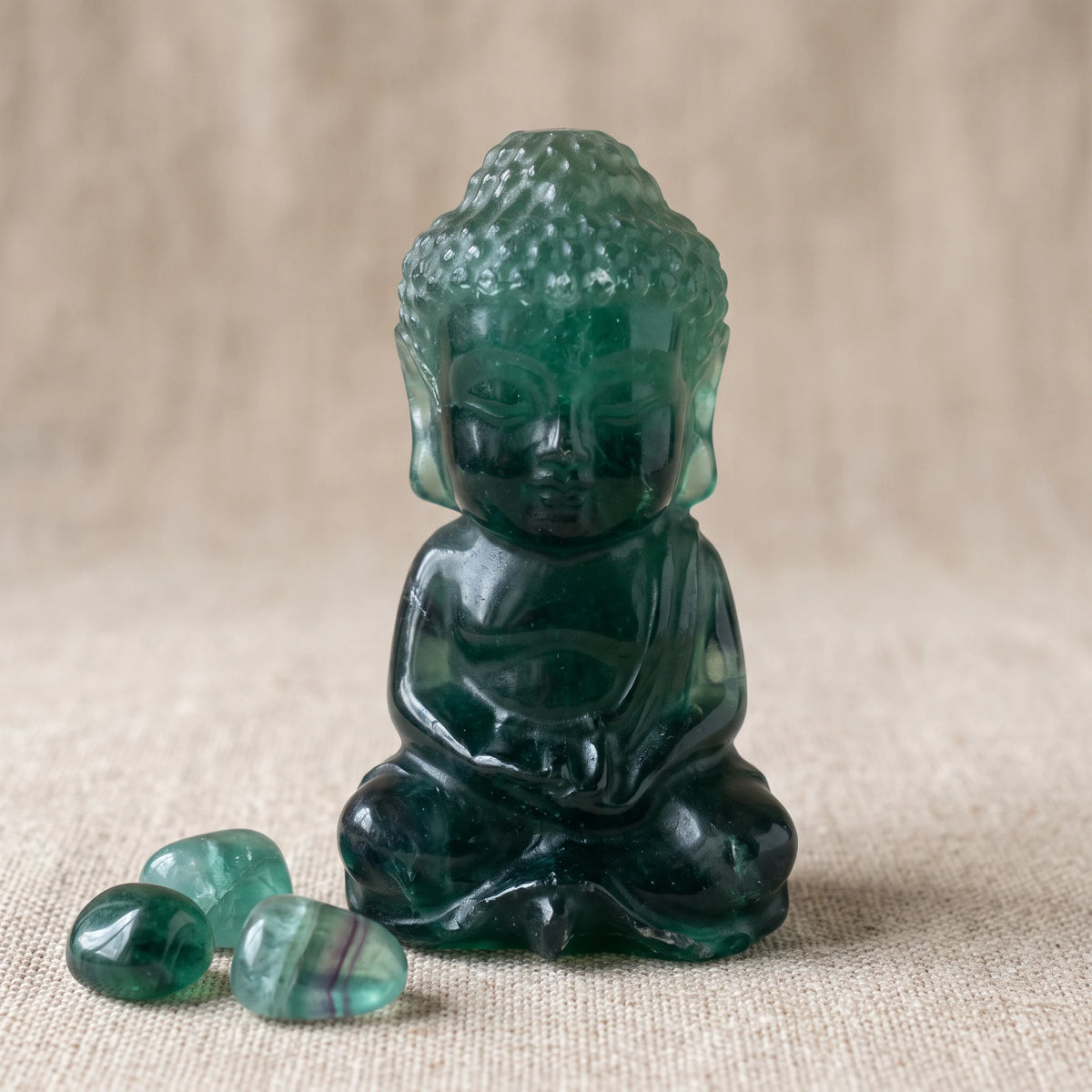 Statue Bouddha en fluorine verte foncée, pierre naturelle avec des pierres roulées