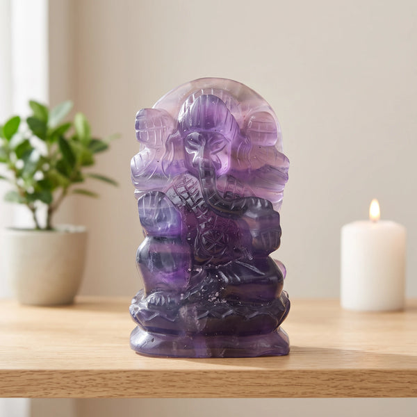 Statue Ganesh violet en fluorite violette posée sur une étagère en bois